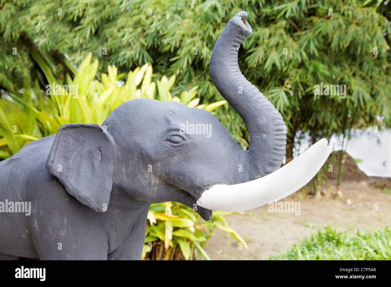 garden feature Indian, elephants head, hand painted amongst the reeds and leafy trees, landscape, horizontal, crop space and cop Stock Photo
