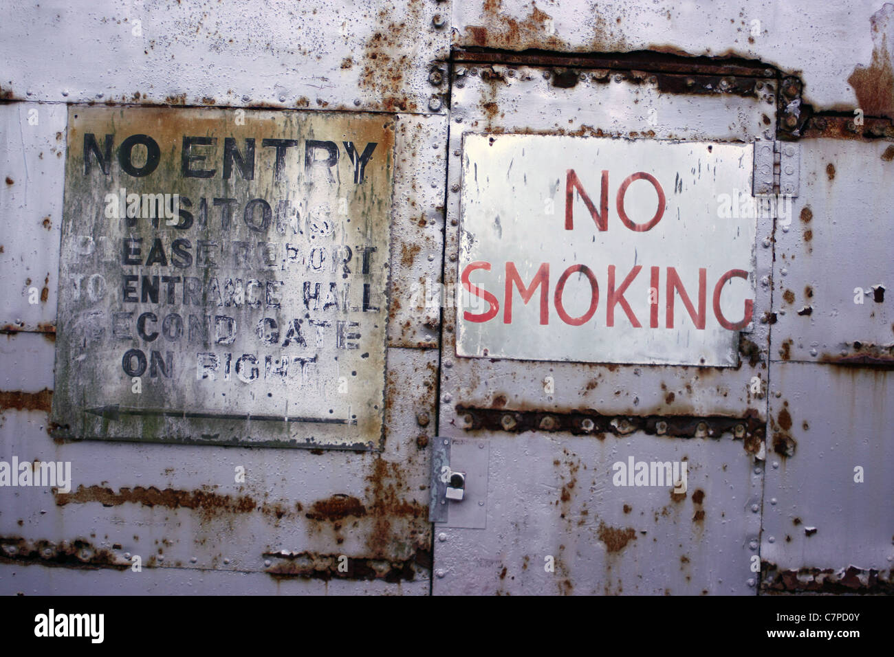 rusty old metal doors with NO SMOKING sign Stock Photo