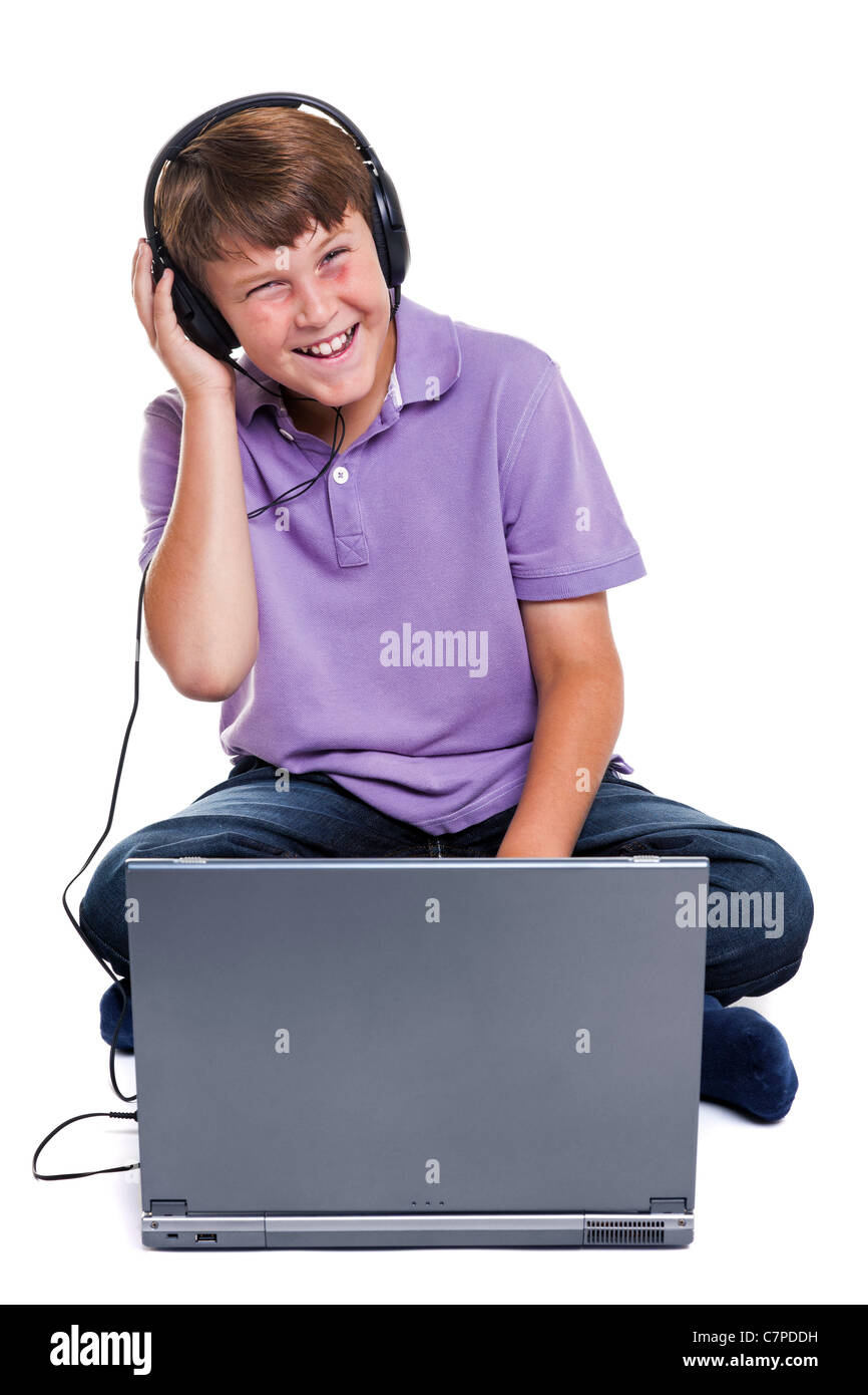 Photo of an 11 year old school boy wearing headphones sitting with a ...