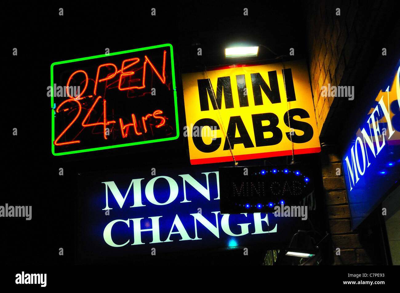 'Open 24hours' 'Money Change' and 'Mini Cabs' neon signs at night Stock Photo