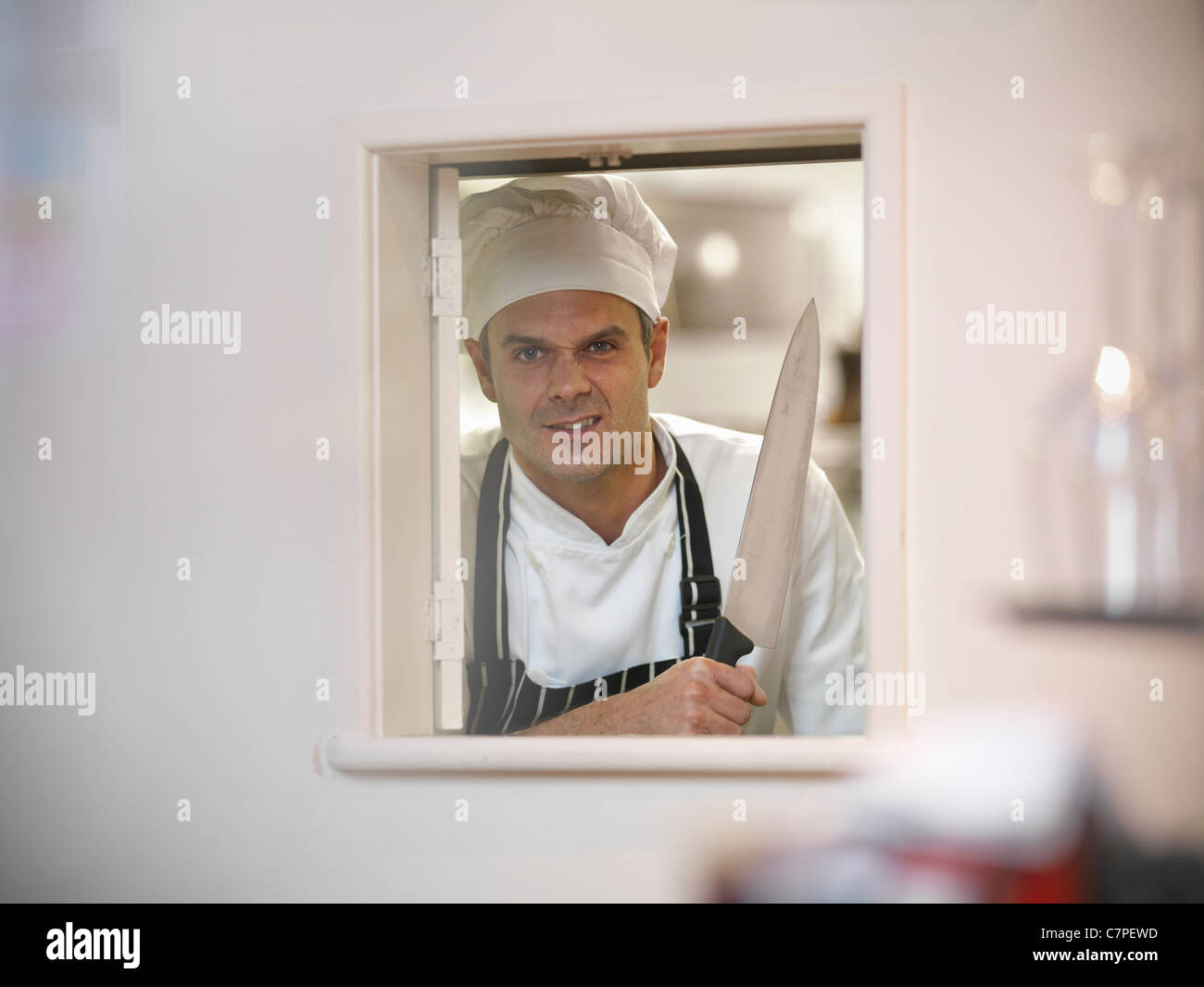 Chef holding large knife in restaurant Stock Photo