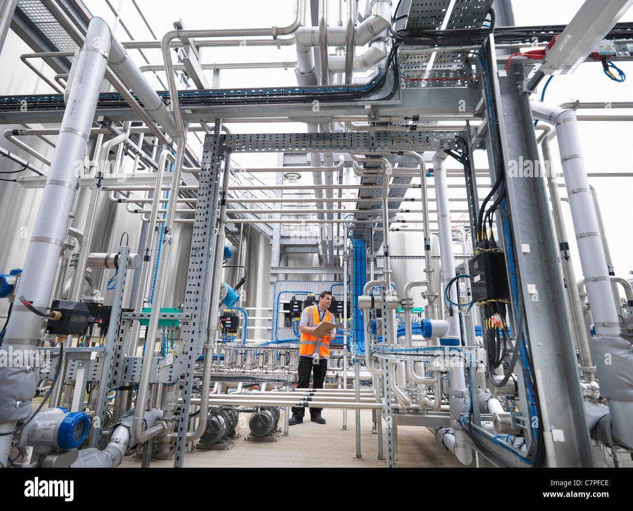 Worker with machinery in bottling plant Stock Photo