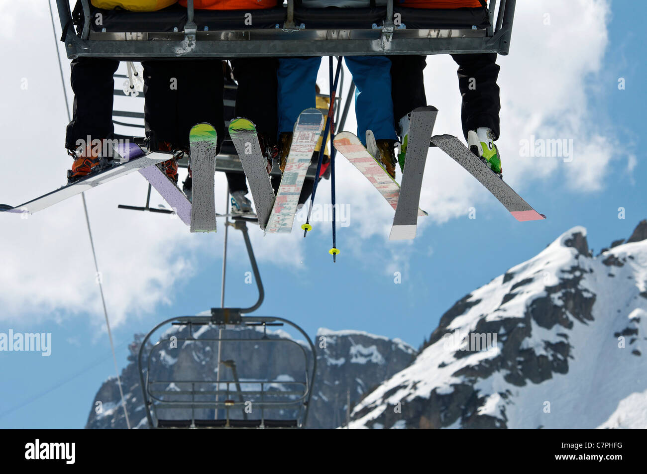 Skiers riding chair lift over mountains Stock Photo - Alamy