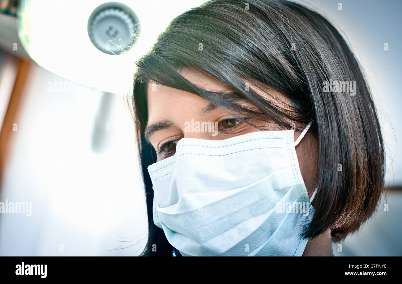 Dentist in face mask working in office Stock Photo