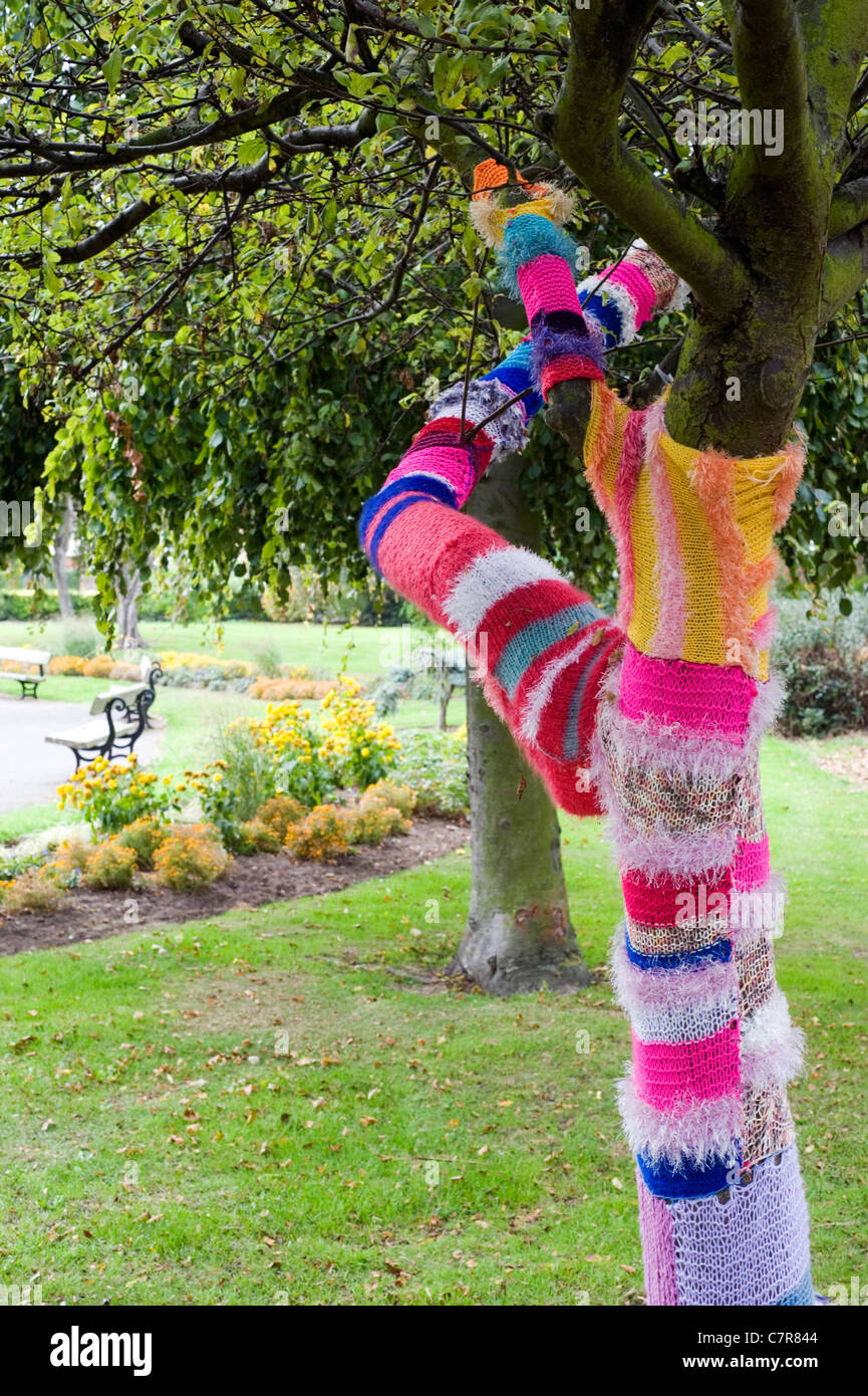 tree that has been yarn bombed in a park in southsea Stock Photo