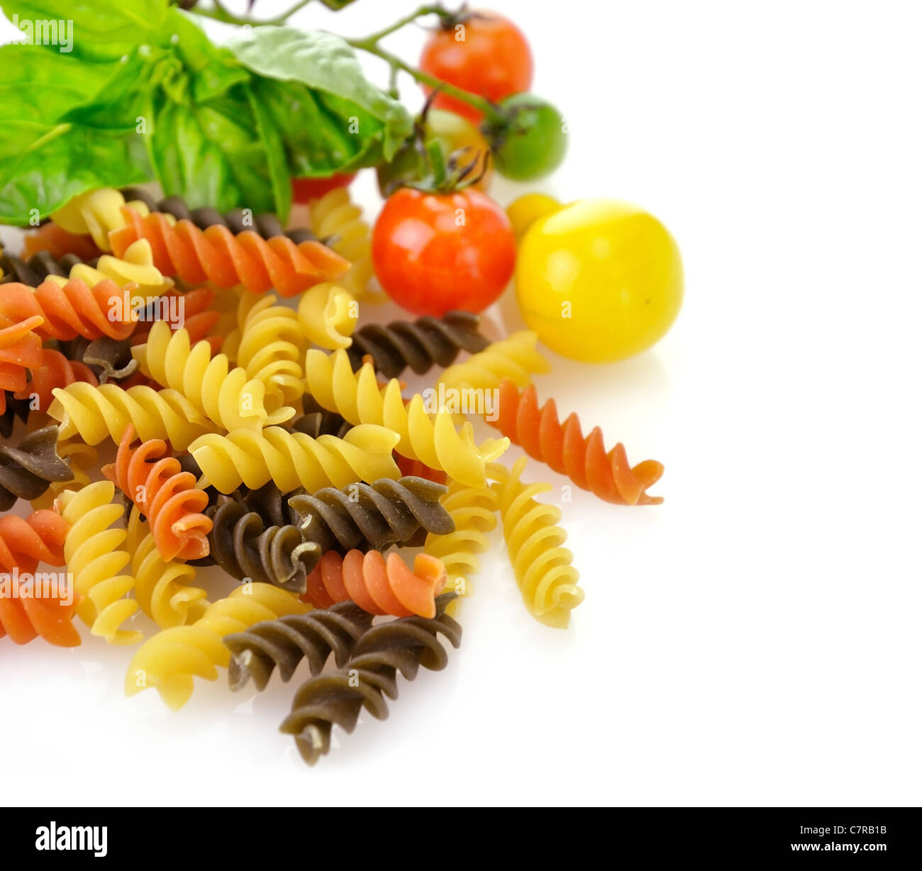 Colorful pasta on white with tomatoes and spices Stock Photo