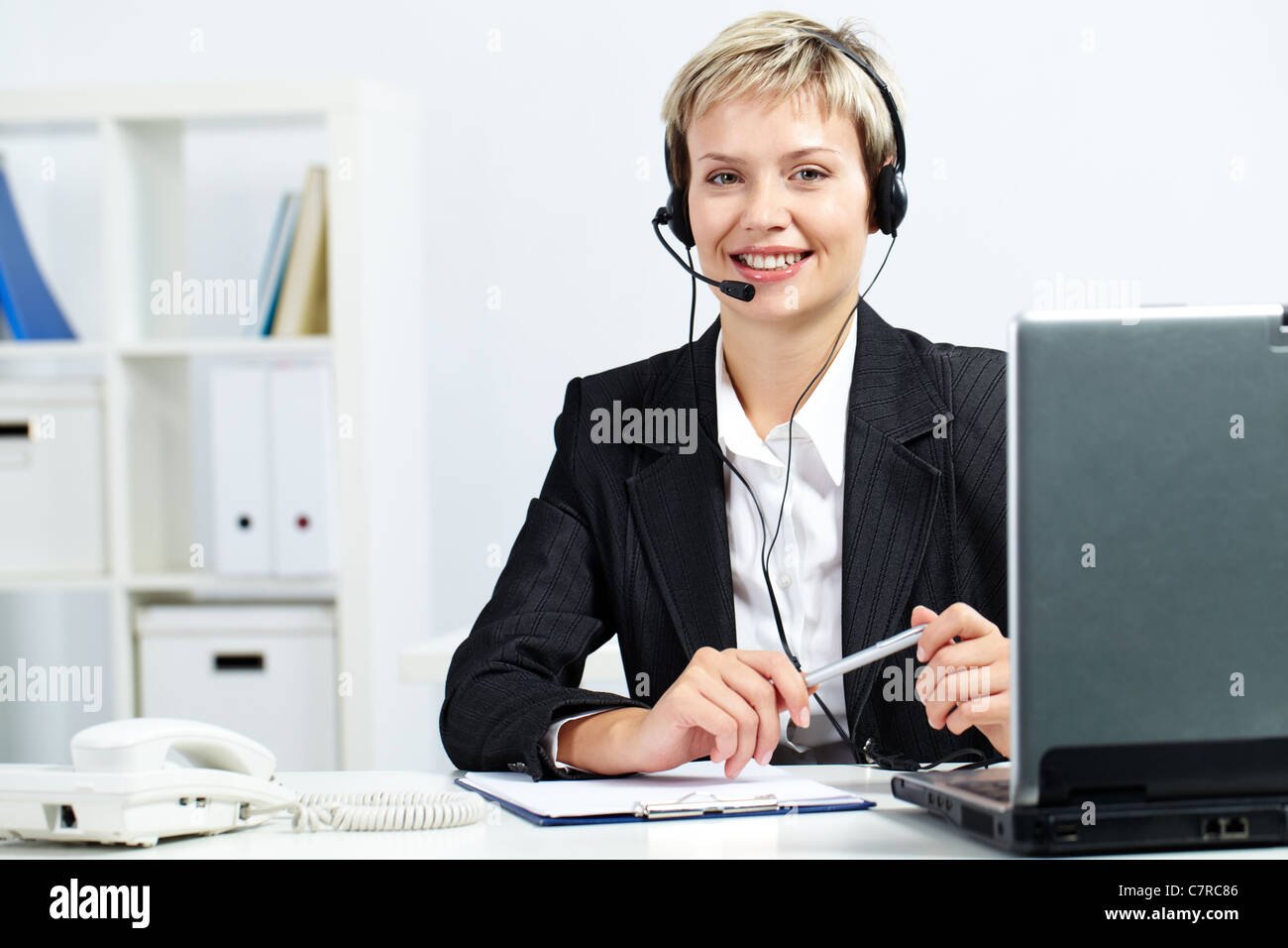 Portrait of a pretty secretary sitting at computer with headset Stock ...
