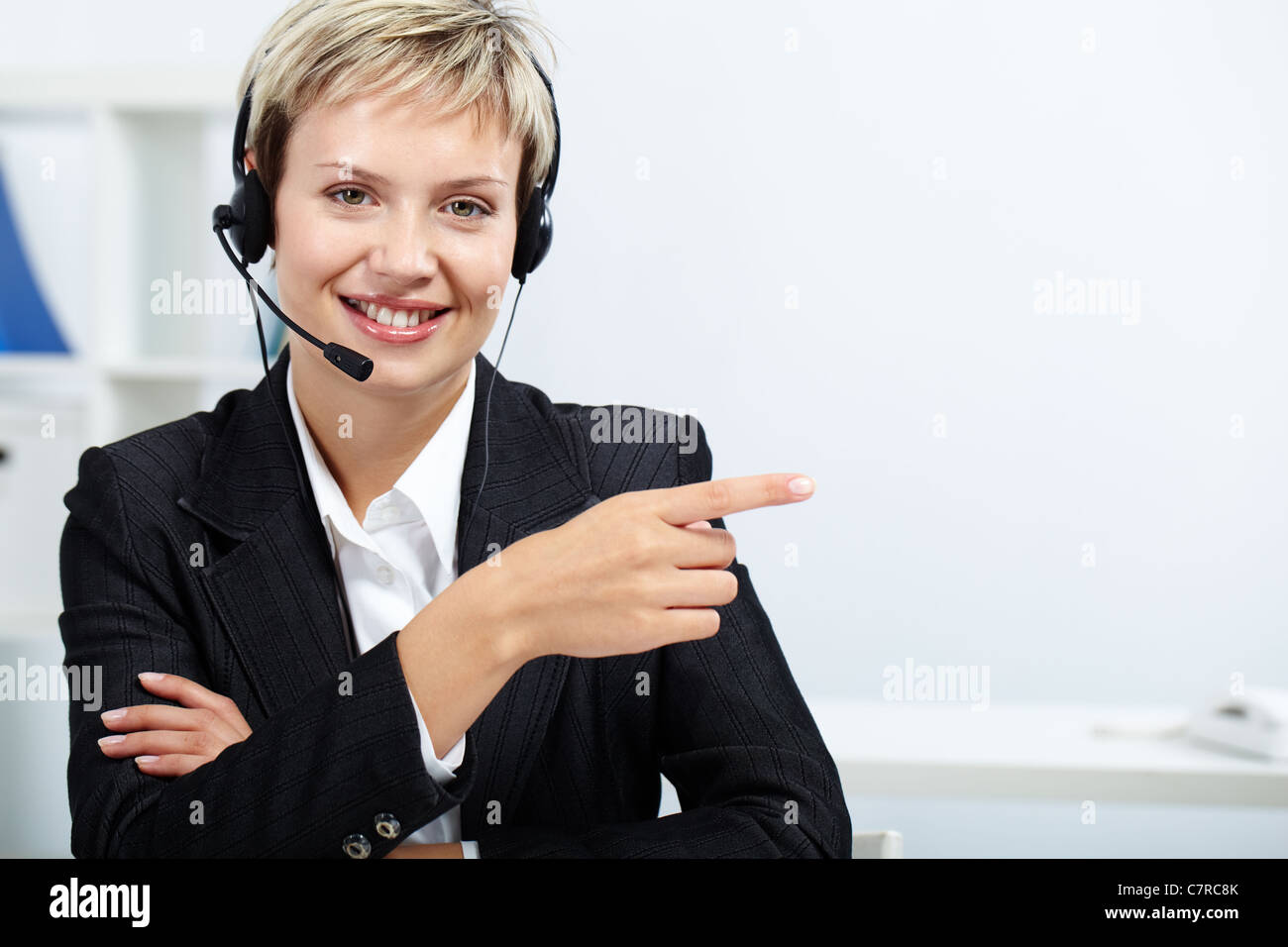 Friendly receptionist with headset showing direction to a visitor Stock  Photo - Alamy