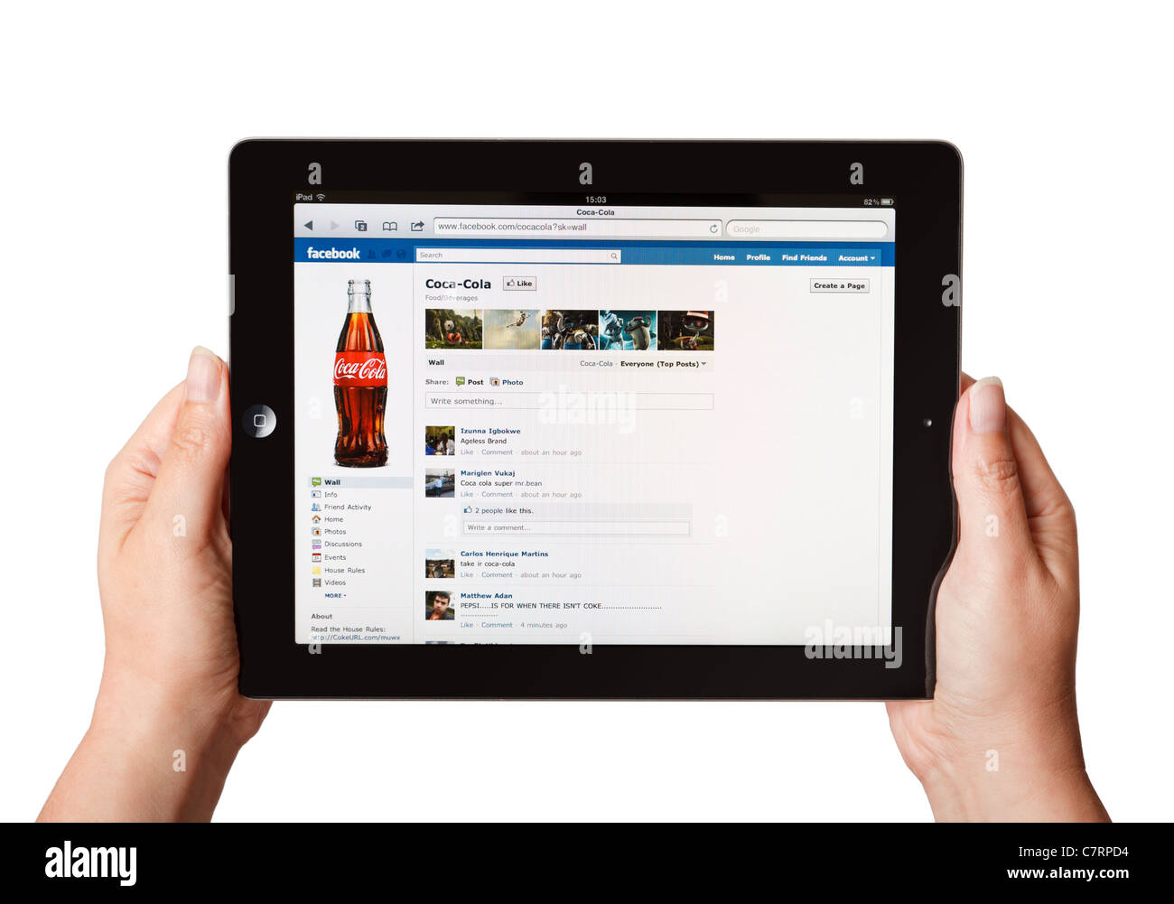 Female hands holding iPad showing online Coca Cola Facebook page Stock Photo
