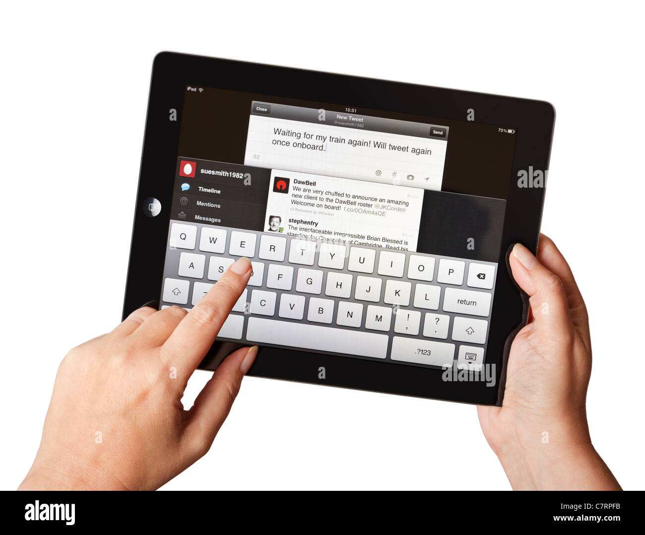 Female hands using iPad writing a tweet on a mobile Twitter application Stock Photo