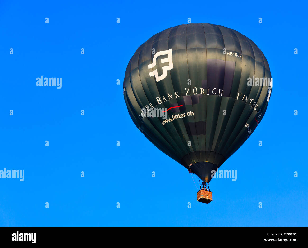 Hot air balloon sponsored by Finter Bank Zurich drifting on a calm sunny afternoon, Italy Stock Photo