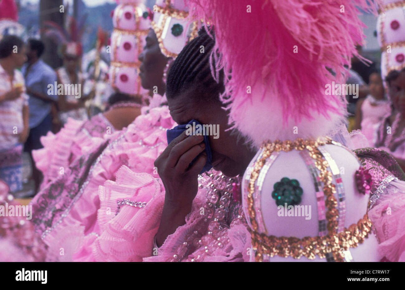 Elderly black woman wearing pink costumes from Mangueira Samba School cries at the end of the parade at dawn Rio carnival Brazil Stock Photo