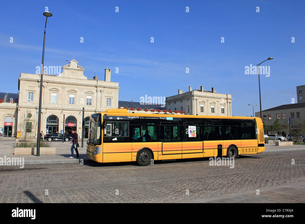 Yellow bus outside train station in Reims in the Champagne-Ardenne region of France Stock Photo