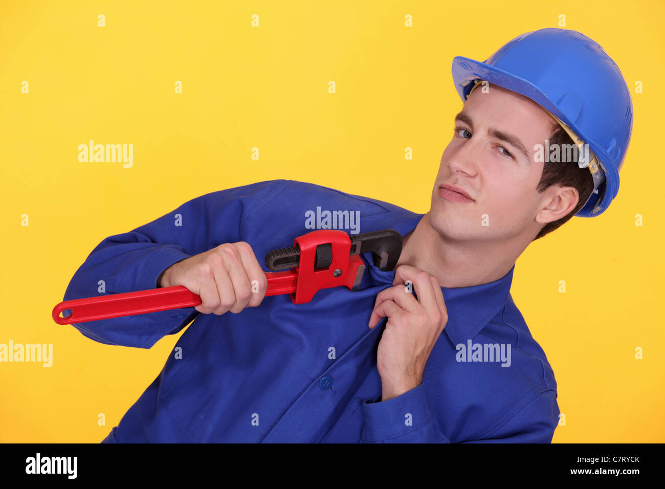 Tradesman's uniform stuck in the jaw of a pipe wrench Stock Photo Alamy