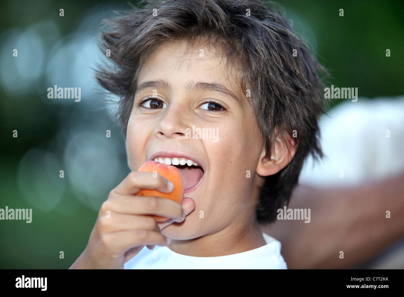 Boy eating an apricot Stock Photo - Alamy