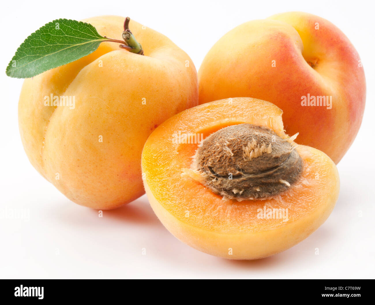 Apricots with leaves on a white background Stock Photo - Alamy