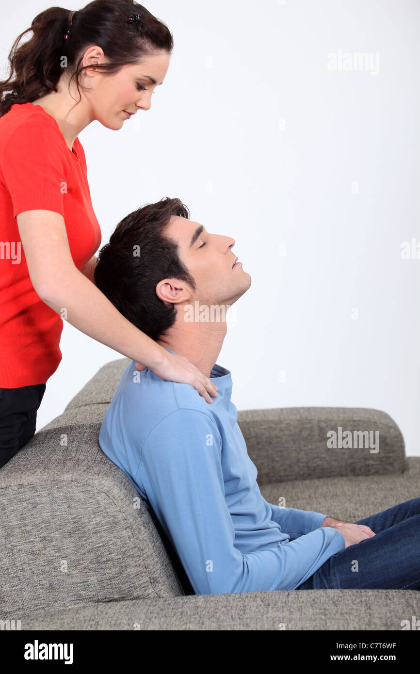 Woman giving husband back massage Stock Photo