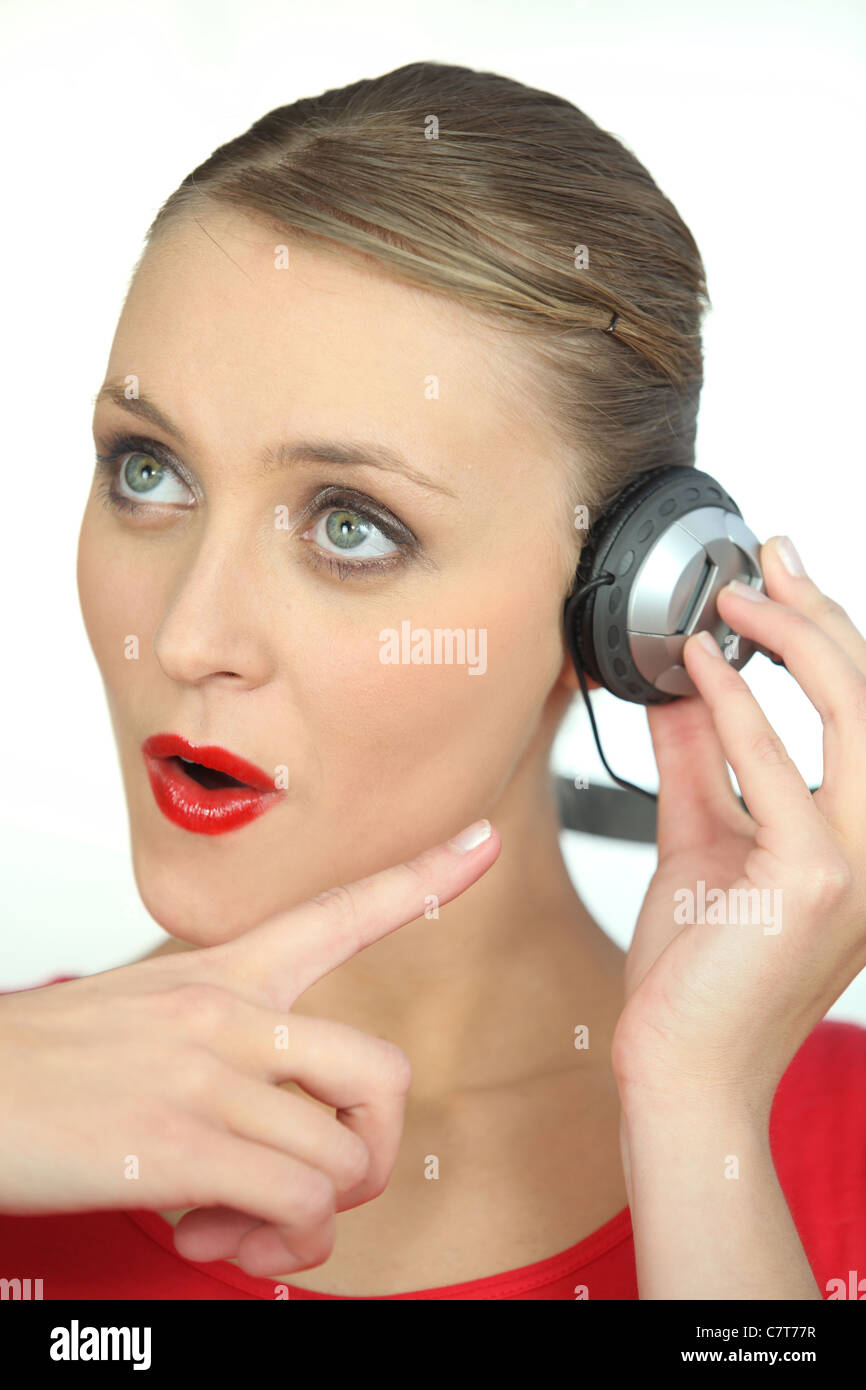 Surprised woman wearing headphones Stock Photo