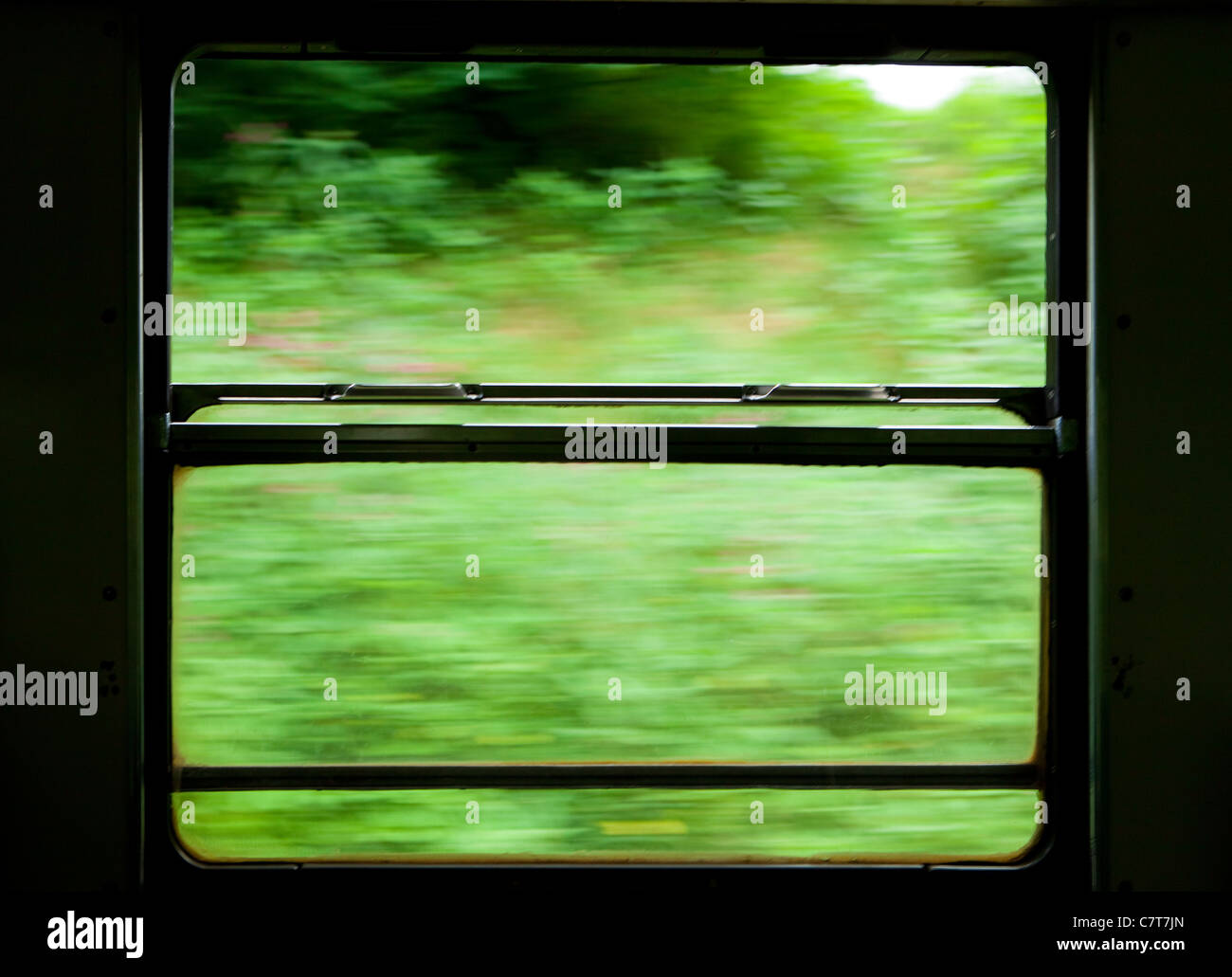 view of moving train window from the inside showing landscape outside