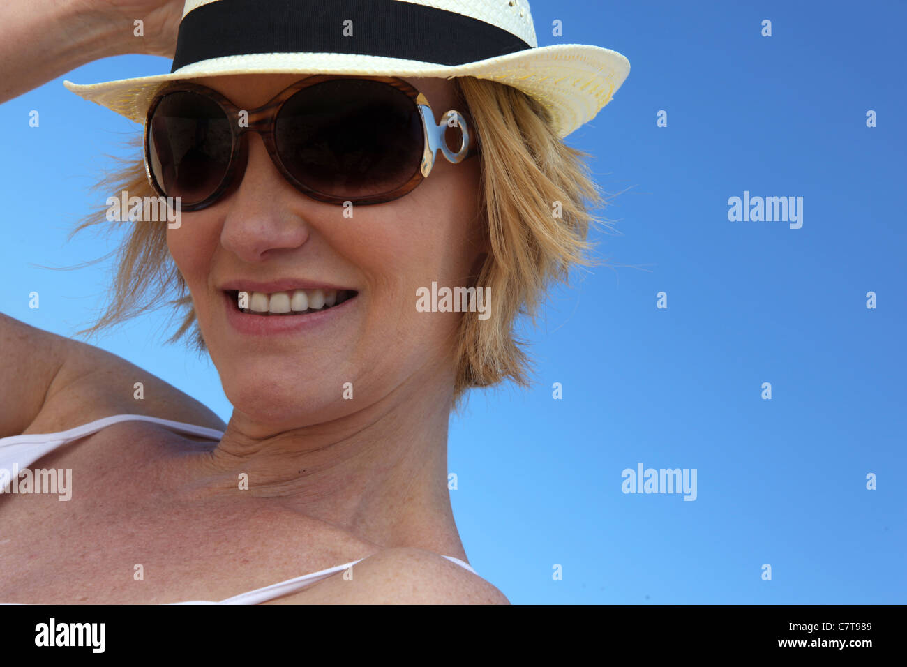 Woman wearing sunglasses and straw hat Stock Photo - Alamy