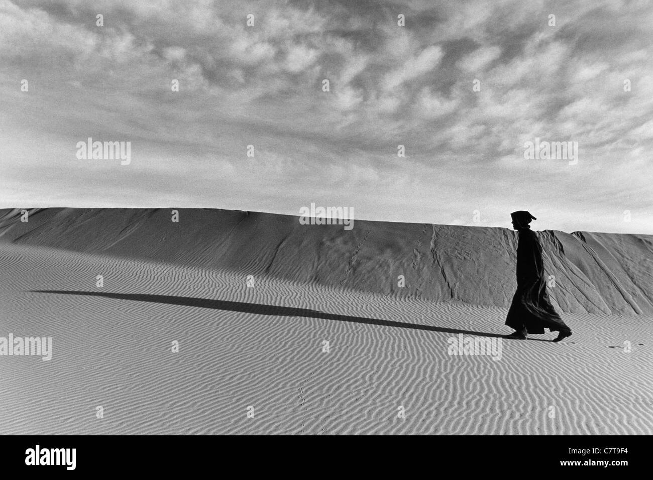 Morocco,Sahara man walking in the desert Stock Photo