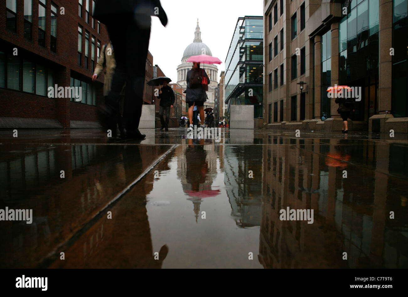 Pedestrians walking along a rainy Peter's Hill towards St Paul's Cathedral, City of London, UK Stock Photo