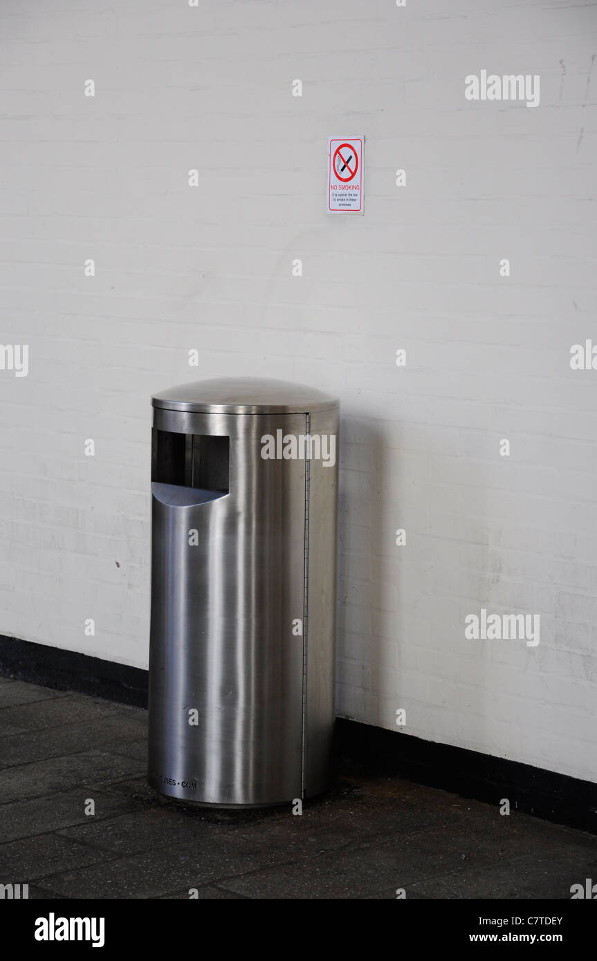 Public waste rubbish bin under a no smoking sign. Stock Photo