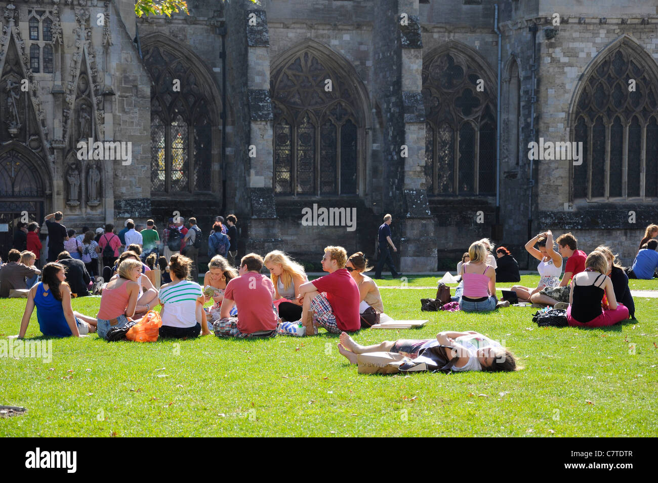 Groups of people outside enjoying sunshine on Cathedral Green, Exeter, Devon Stock Photo