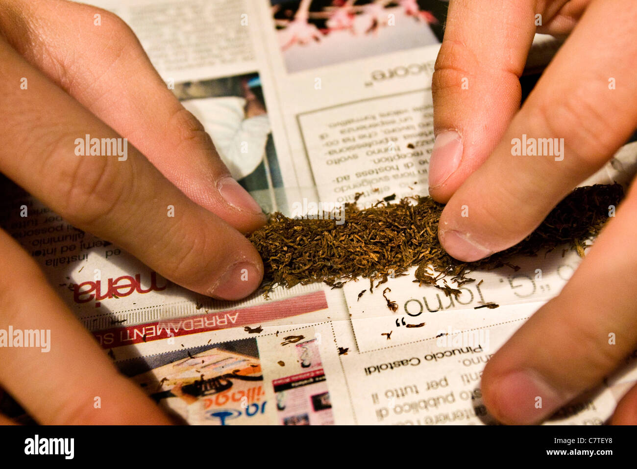 Young man's hands rolling marijuana joint, close up Stock Photo