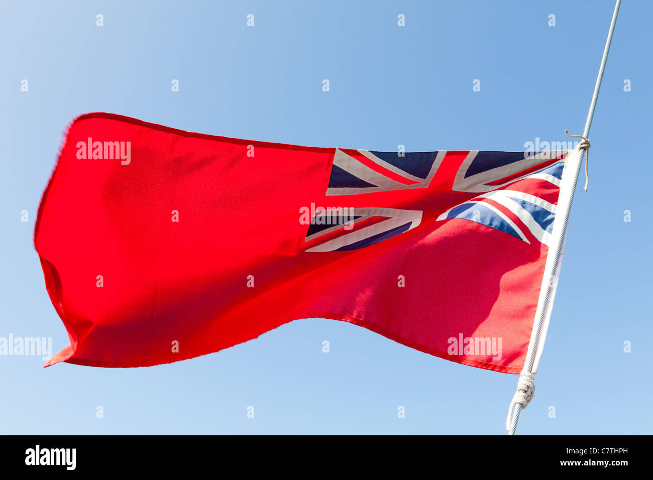 The red ensign, known as the red duster, flying in the breeze against a blue sky Stock Photo