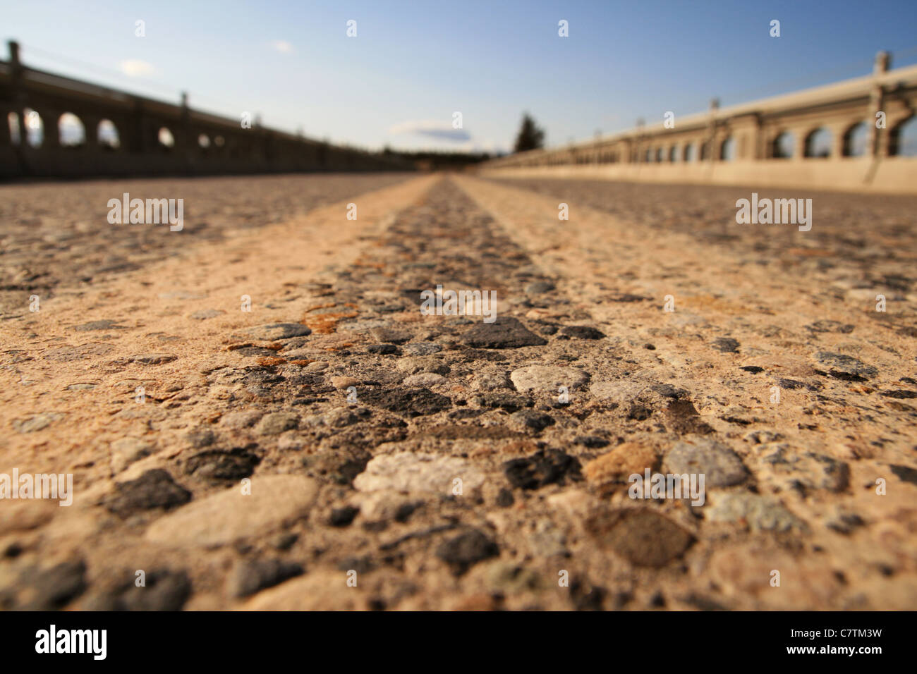 view from very close to the pavement in the center of the roadway on a bridge with very shallow depth of field Stock Photo