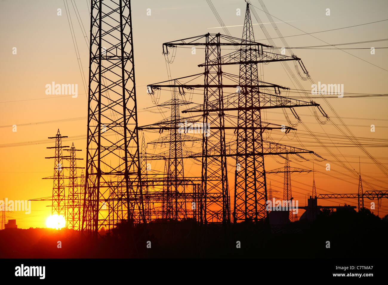 High-voltage power lines, pylons at sunset. Essen, Germany Stock Photo ...