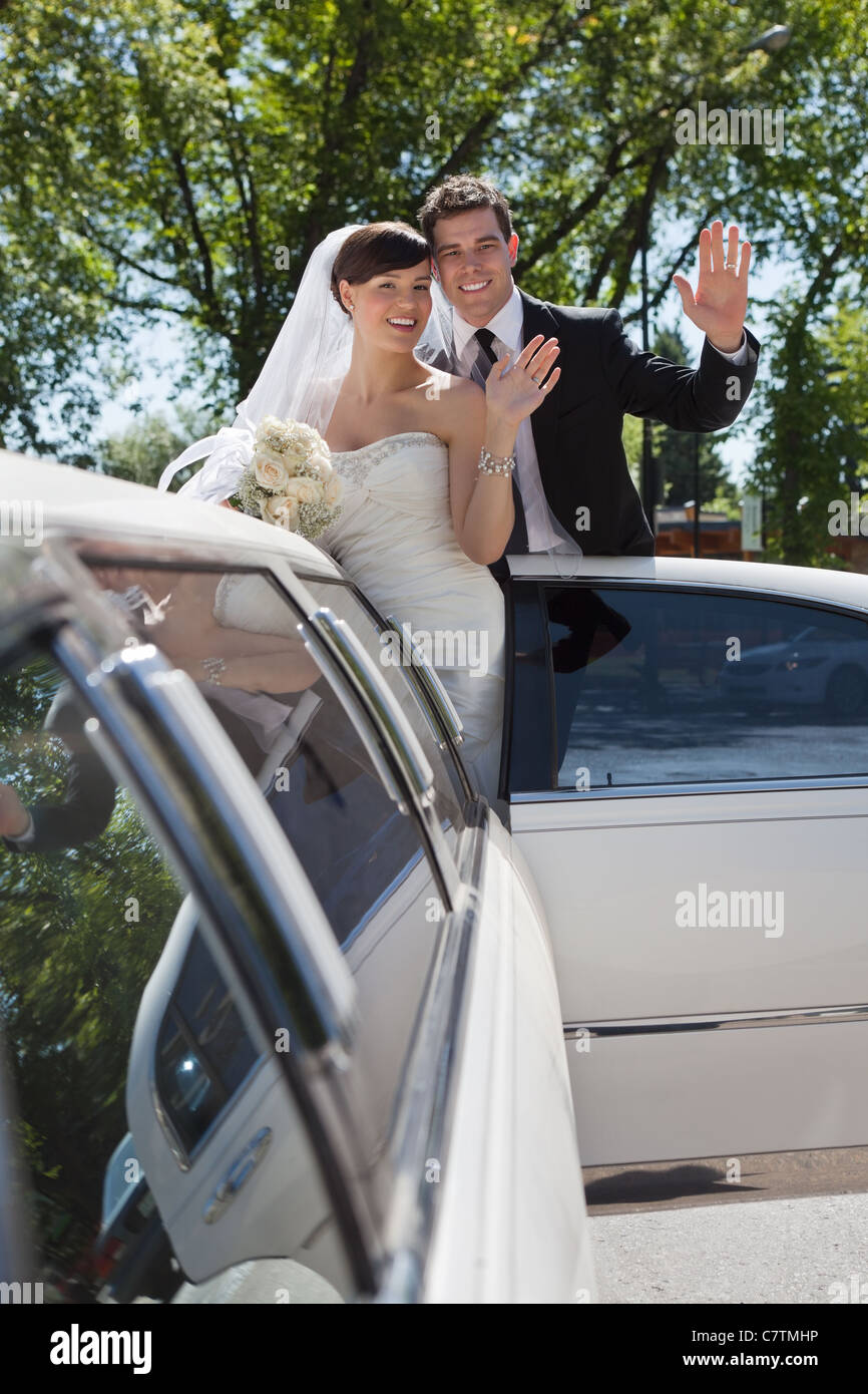 Bride and groom standing in Limo waving Stock Photo - Alamy
