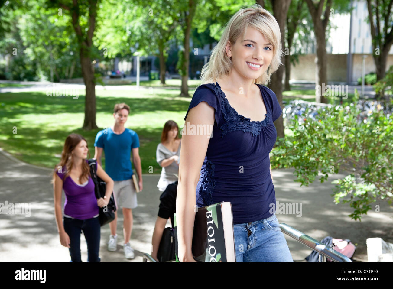 pretty-college-girl-going-to-college-with-friends-in-background-stock