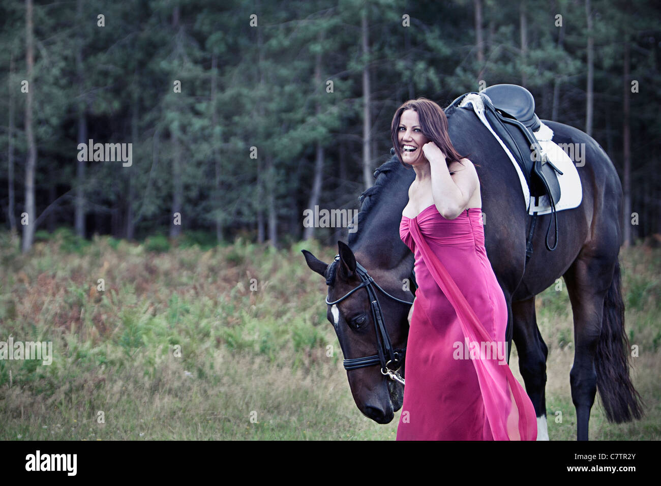 Beautiful Photo of Woman in Pink Dress with Horse in Forest Location Stock Photo