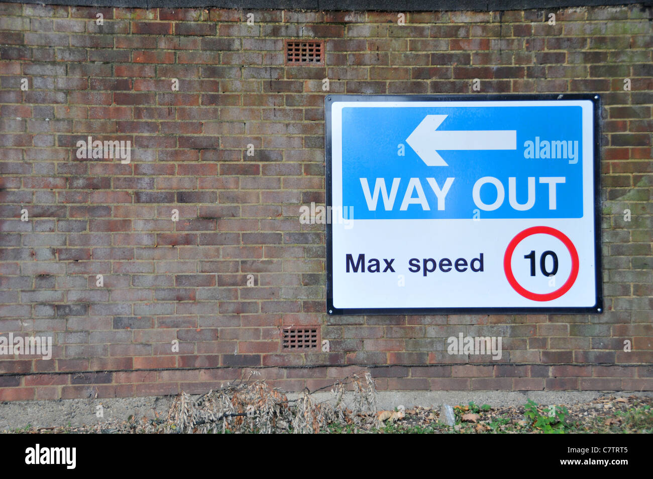 Way Out road sign signage arrow directions speed limit 10 mph Stock Photo