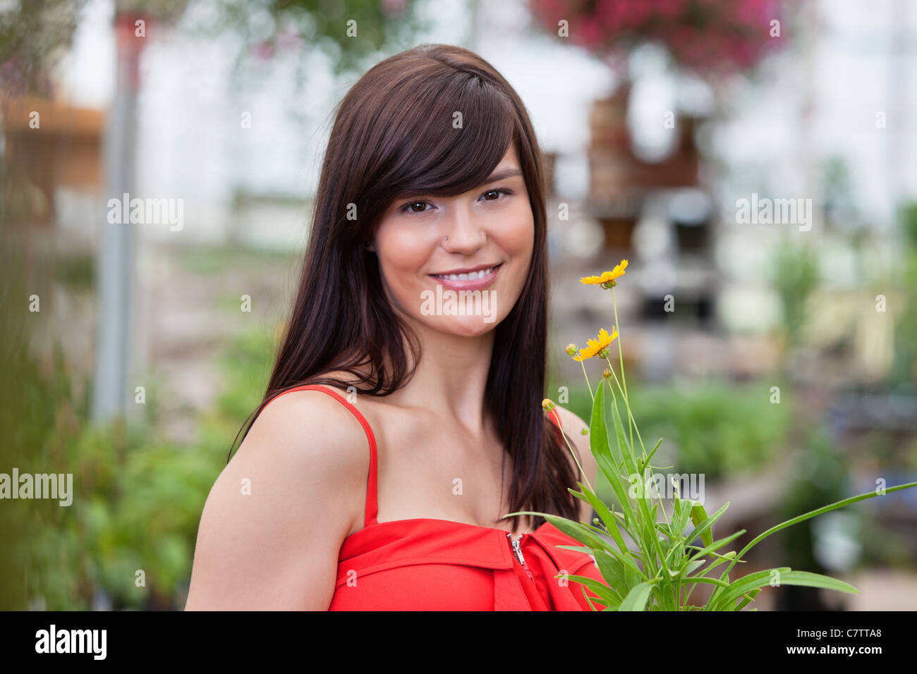 Portrait of beautiful smiling woman holding flower pot Stock Photo - Alamy