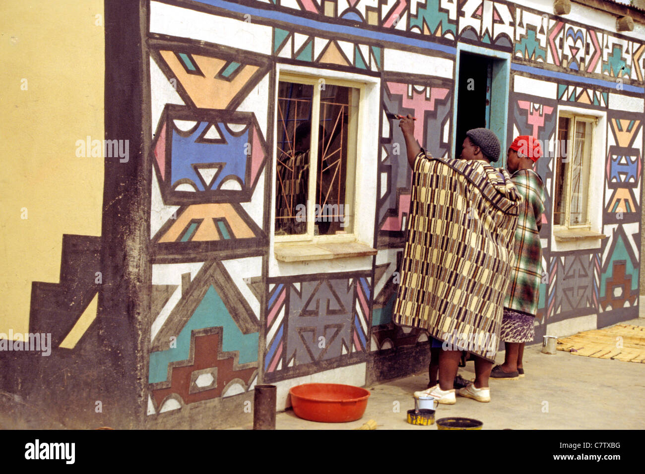South Africa, Ndebele, woman painting the wall of her home Stock Photo