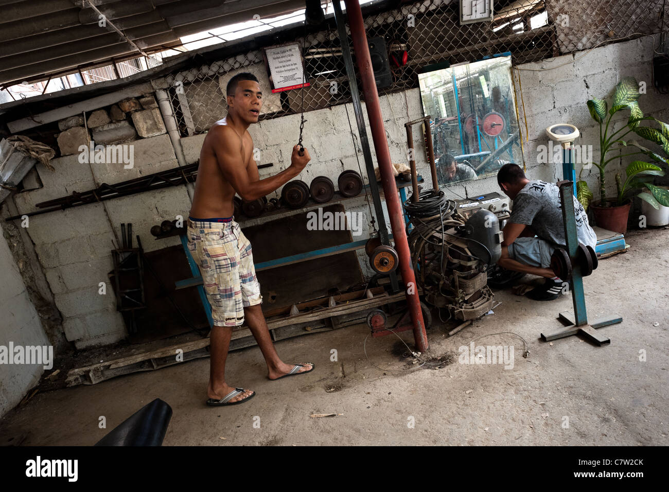 A young Cuban man does fitness exercise with barbells at a bodybuilding gym in Alamar, Havana, Cuba. Stock Photo