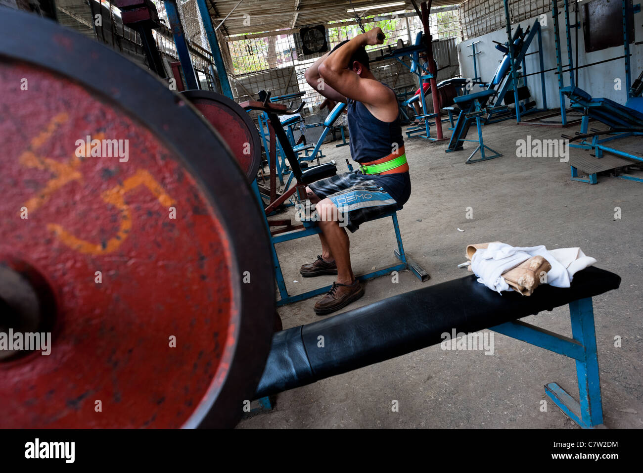 A Cuban man does exercise at a bodybuilding gym in Alamar, a public housing complex in the Eastern Havana, Cuba. Stock Photo