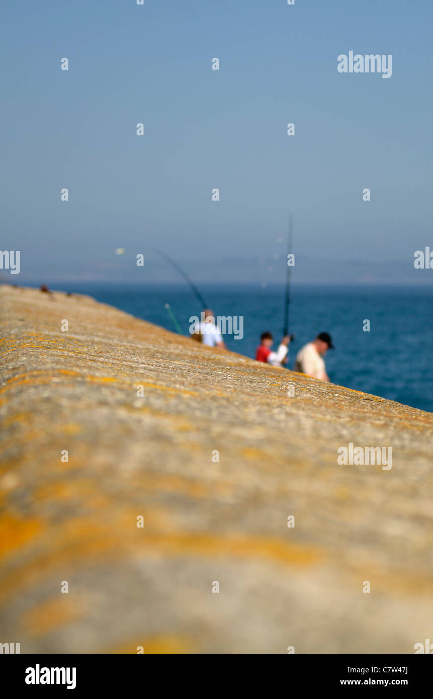 Shallow focus shot of men fishing Mevagissey Cornwall UK Stock Photo