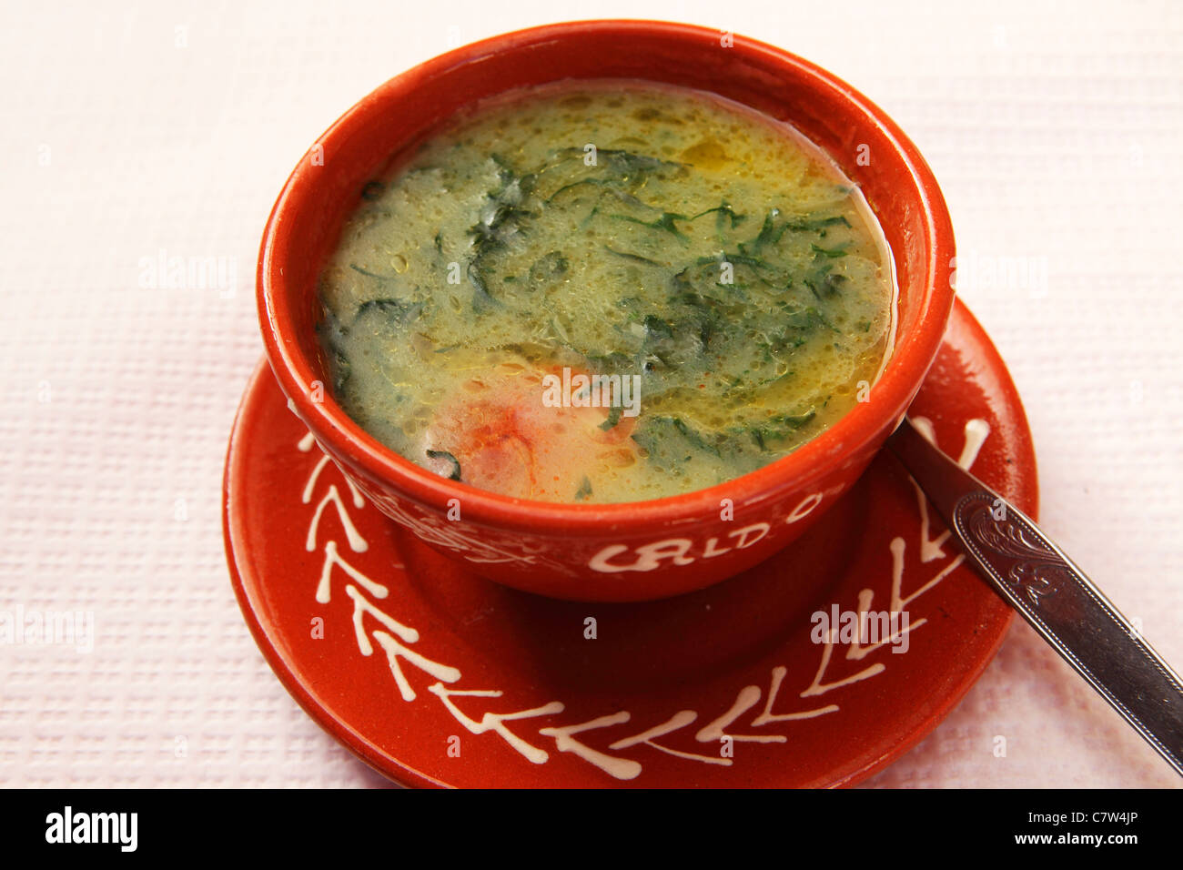 A bowl of Caldo Verde soup is served in a traditional earthenware bowl in a Portuguese restaurant. Stock Photo