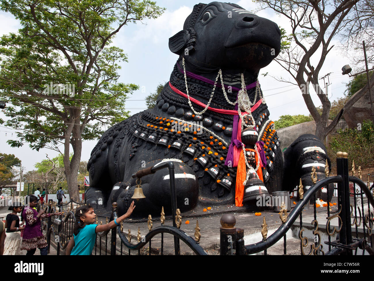 Hindu girls worshiping the sacred Nandi Bull (Shiva's vehicle). Chamundi hill. Mysore. India Stock Photo