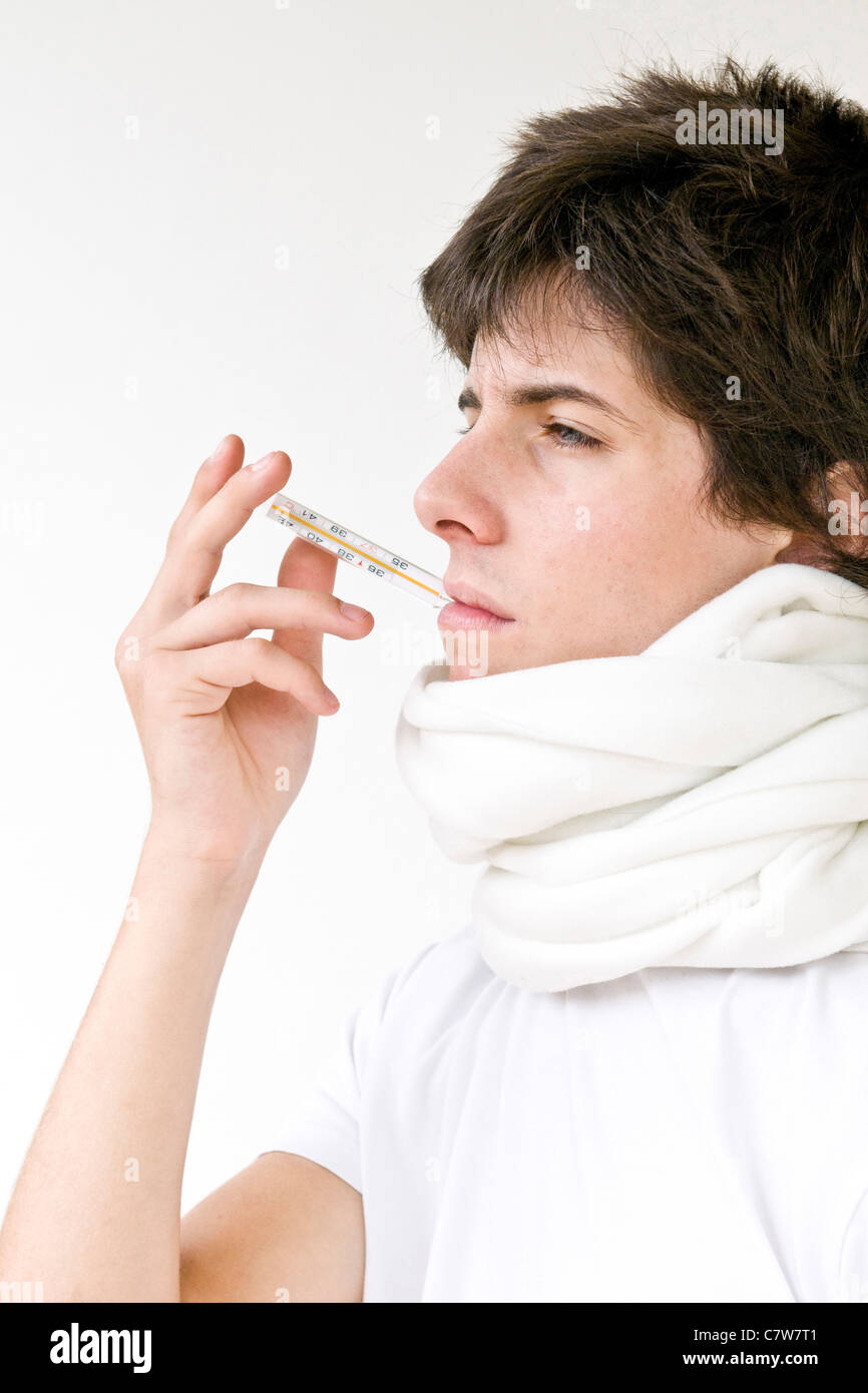 Teenage boy with thermometer in mouth Stock Photo