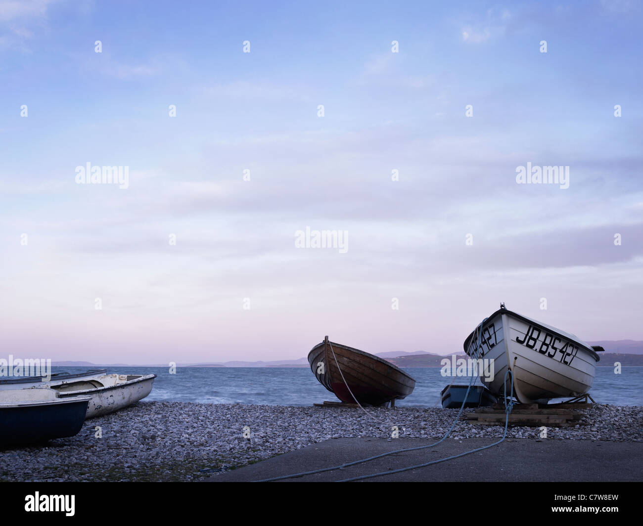 Fishing Boats on the beach at dusk in Anglesey North Wales with sunset