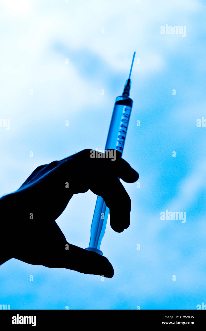 Hand holding syringe Stock Photo