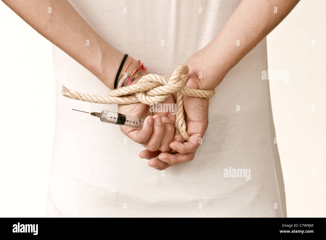 Man with hands tied up with holding syringe Stock Photo - Alamy