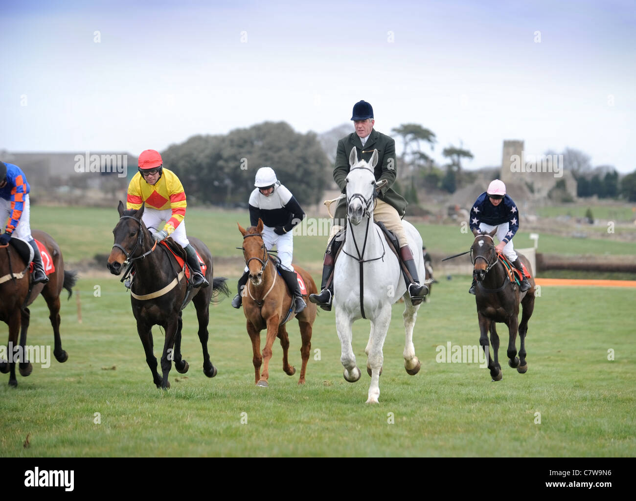 Sheknowsyouknow ridden by M. Wall (left, red diamond on silks) is escorted back after winning the Hunt members opening race at t Stock Photo