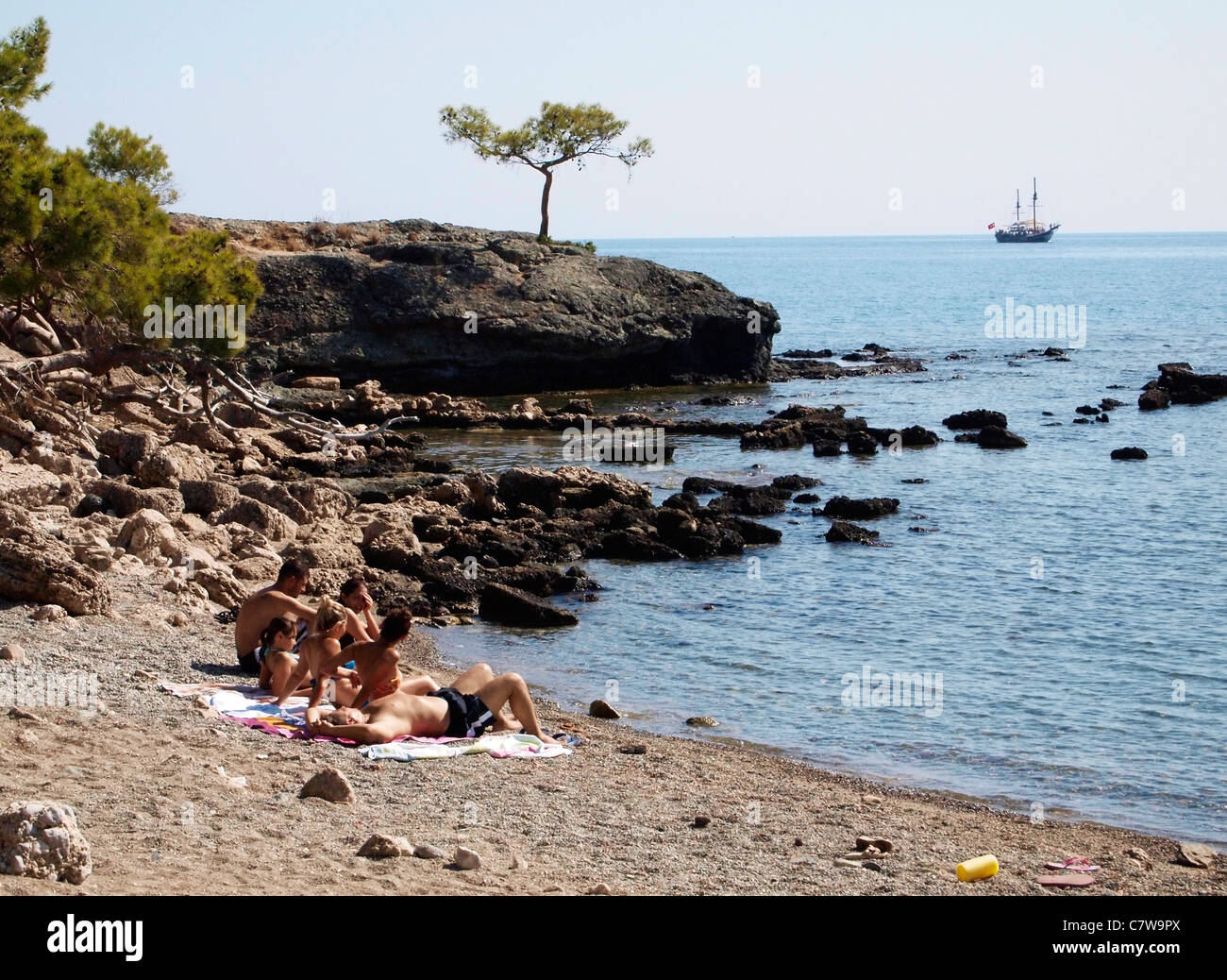 SUN BATHING ON ROCKY BEACH THE LYIAN CITY OF PHASELIS NEAR KEMER TURKEY
