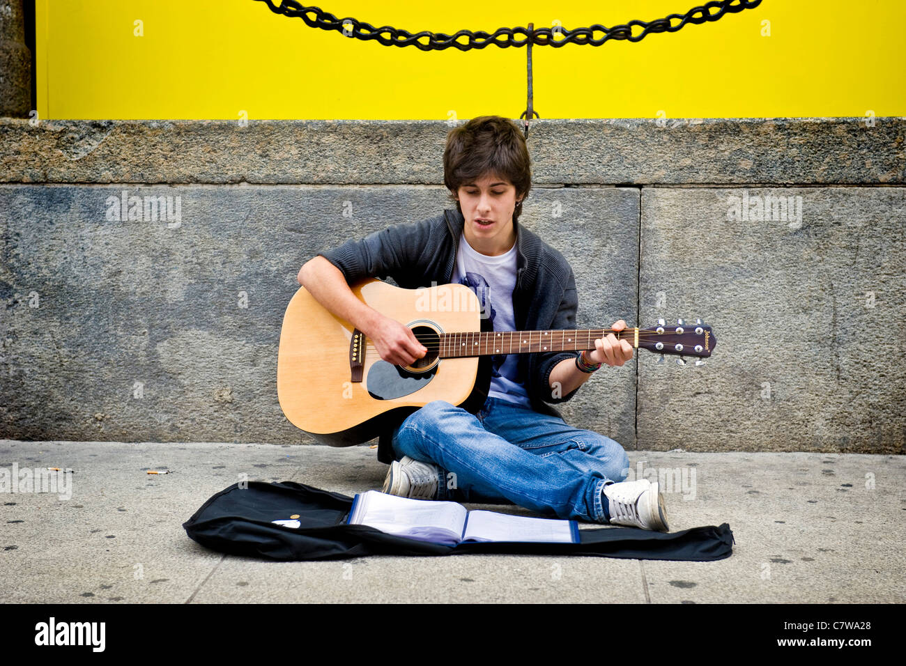 Teenage boy playing guitar in the street Stock Photo
